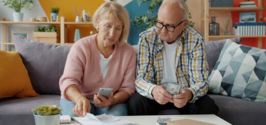 Elderly couple looking at bills and phone