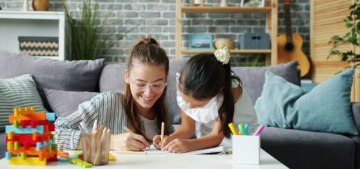 Woman and child drawing together on a couch.