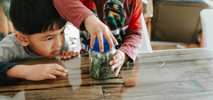 two children are playing with a jar of money