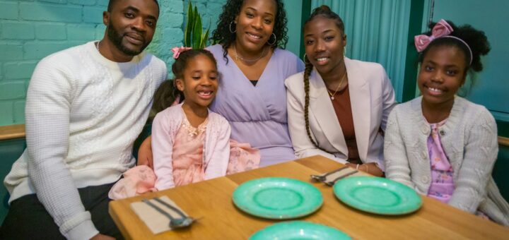 a group of people sitting around a wooden table